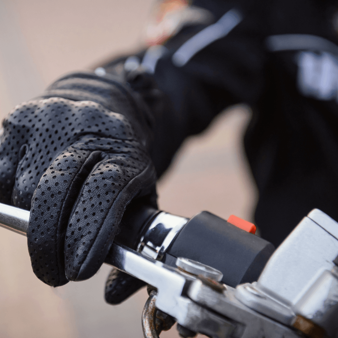 gloved hand gripping motorcycle handlebar