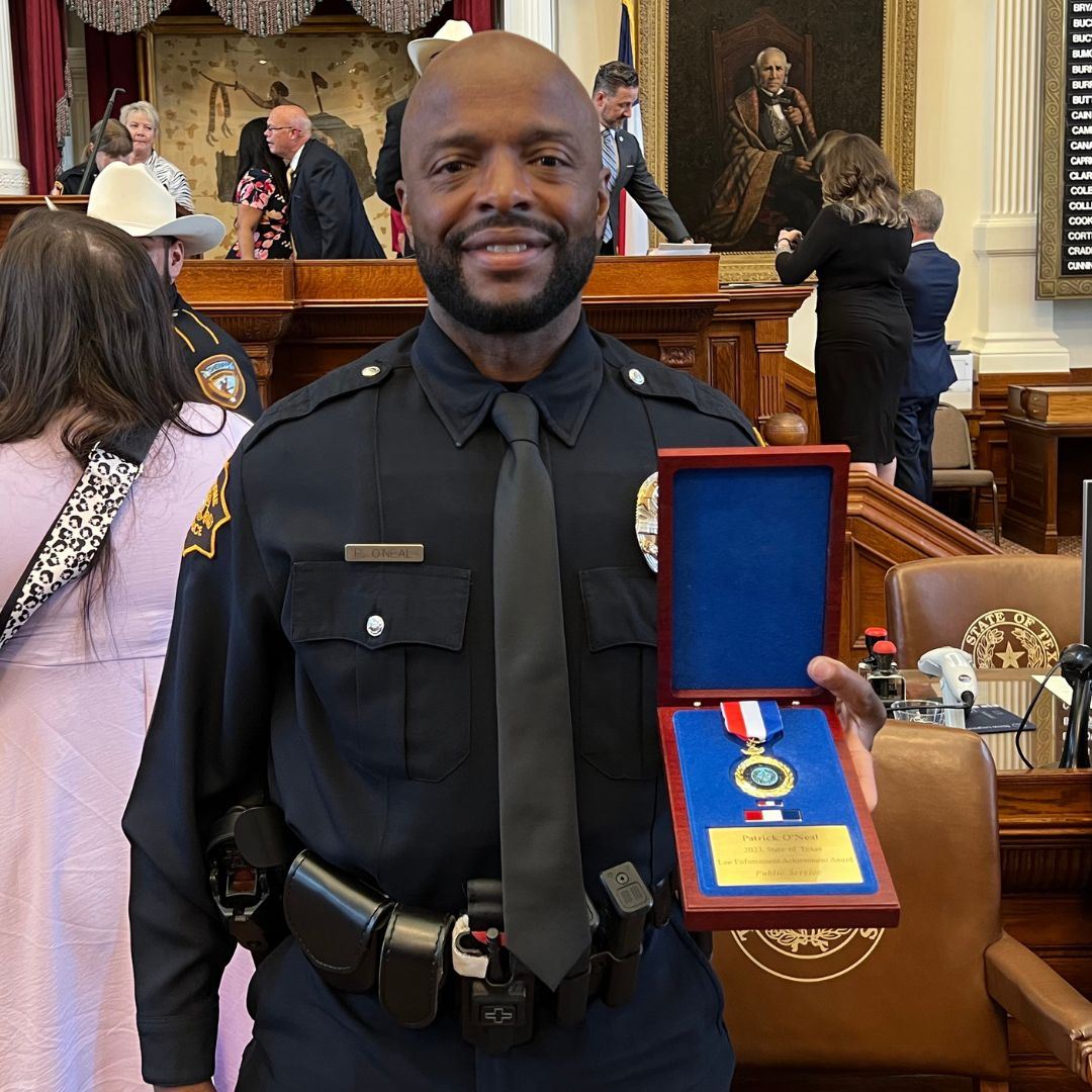 Officer Patrick Oneal holding state award medal
