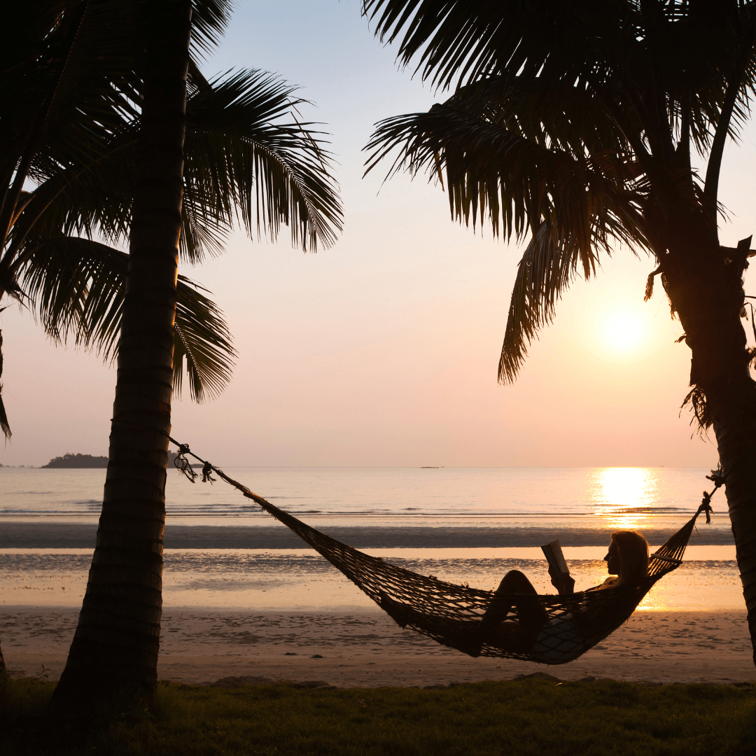 woman in hammock by palm trees