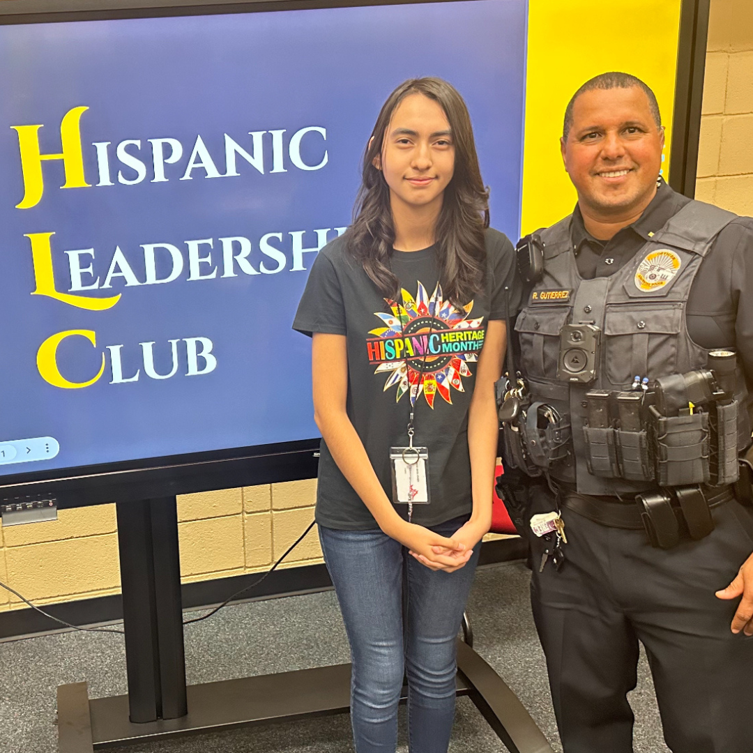 member of Hispanic Leadership Club stands with Grapevine police officer