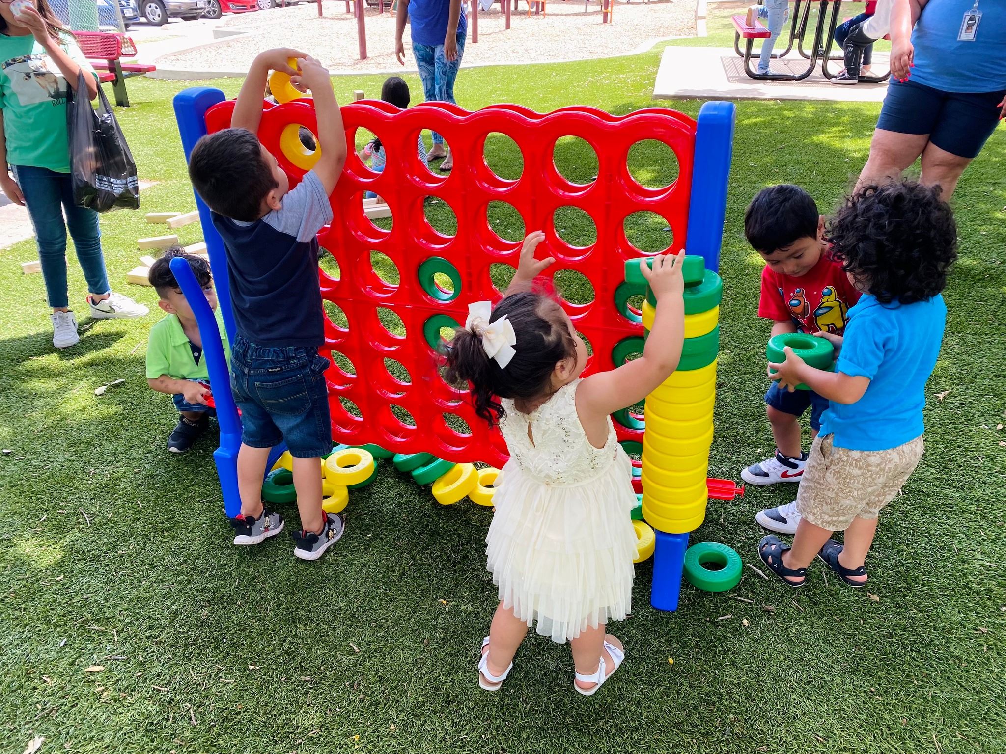 children playing with giant connect 4 game outside